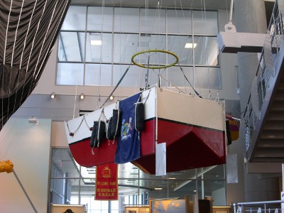 [Red and white balloon gondola hanging from ceiling of museum.]